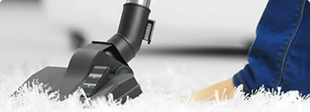 Close-up of a professional vacuuming a white carpet in Parrish.